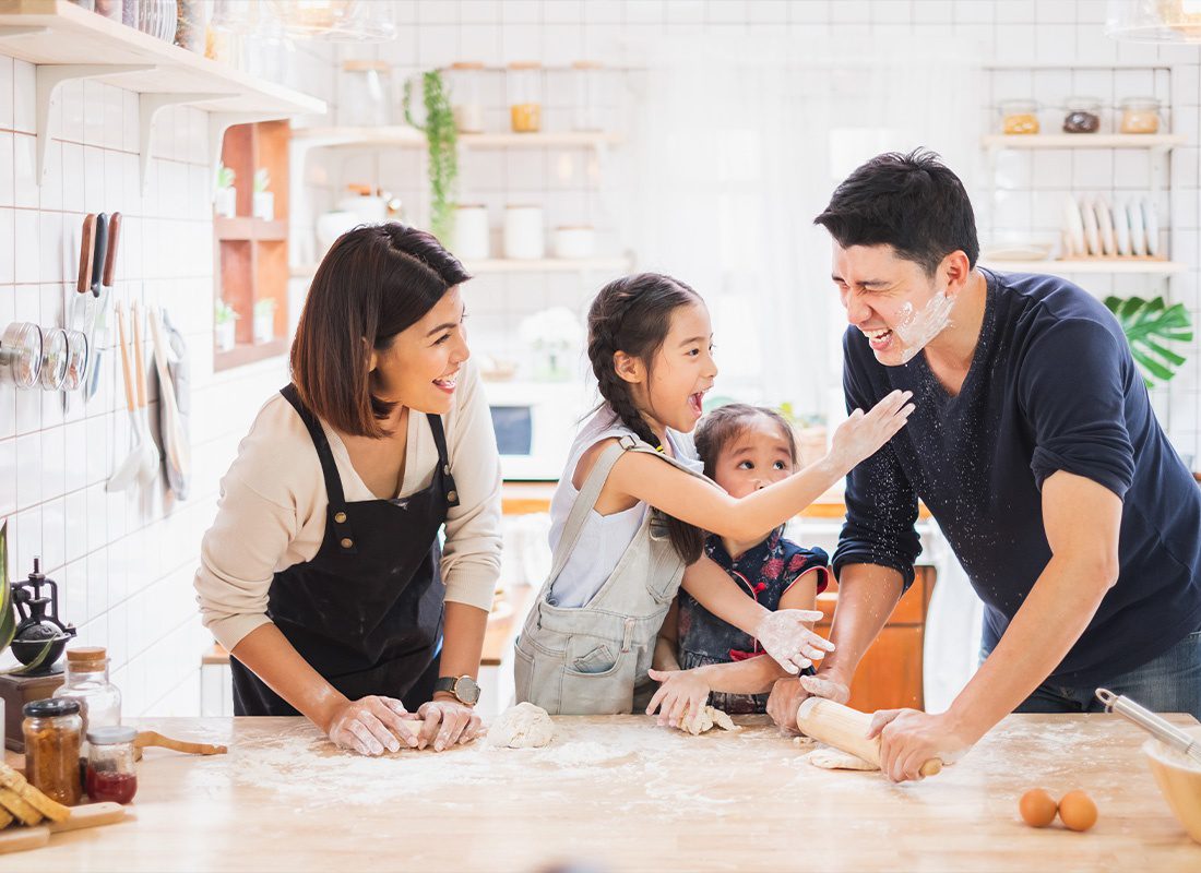 Personal Insurance - Young Family Having Fun While Baking at Home in Their Kitchen